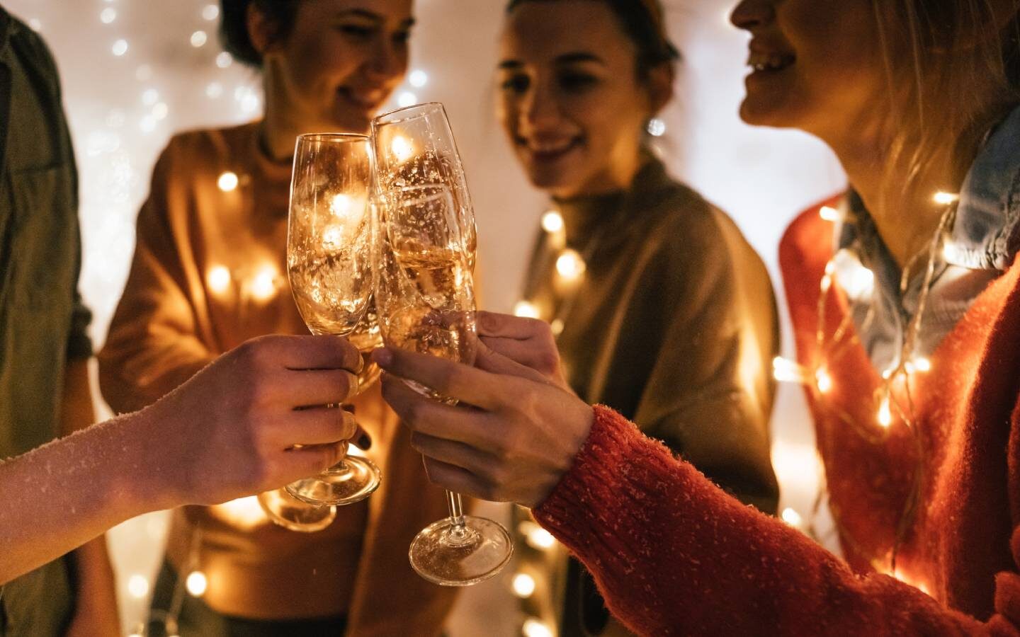 a group of people standing around each other holding wine glasses
