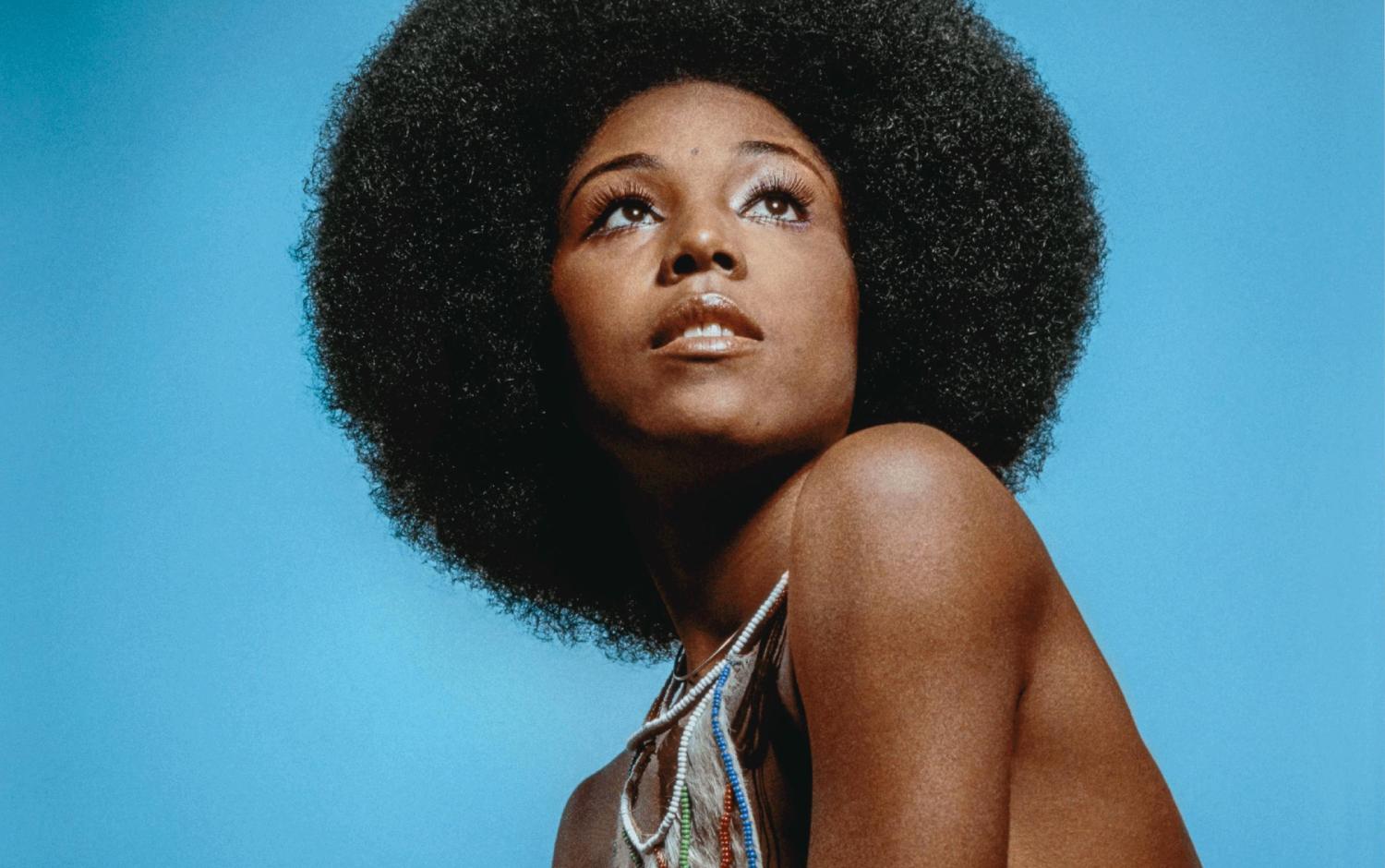 a woman with an afro is posing for a picture